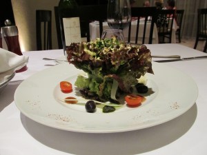 The salad was tied (with an artichoke ribbon) and standing up on the plate.  The dressing was sprinkled on top and the olives, cheeses and tomatoes were around the outside!  Beautiful!